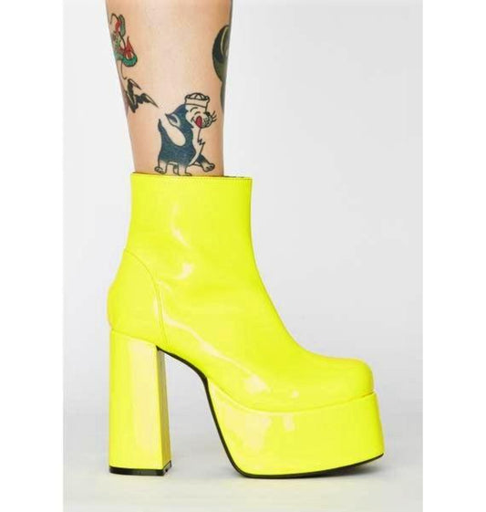 Glossy yellow patent leather platform gogo boots. Ankle length with round toe and chunky block heel. Inspired by the 1960's gogo boots.