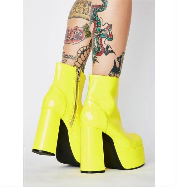 Glossy yellow patent leather platform gogo boots. Ankle length with round toe and chunky block heel. Inspired by the 1960's gogo boots.