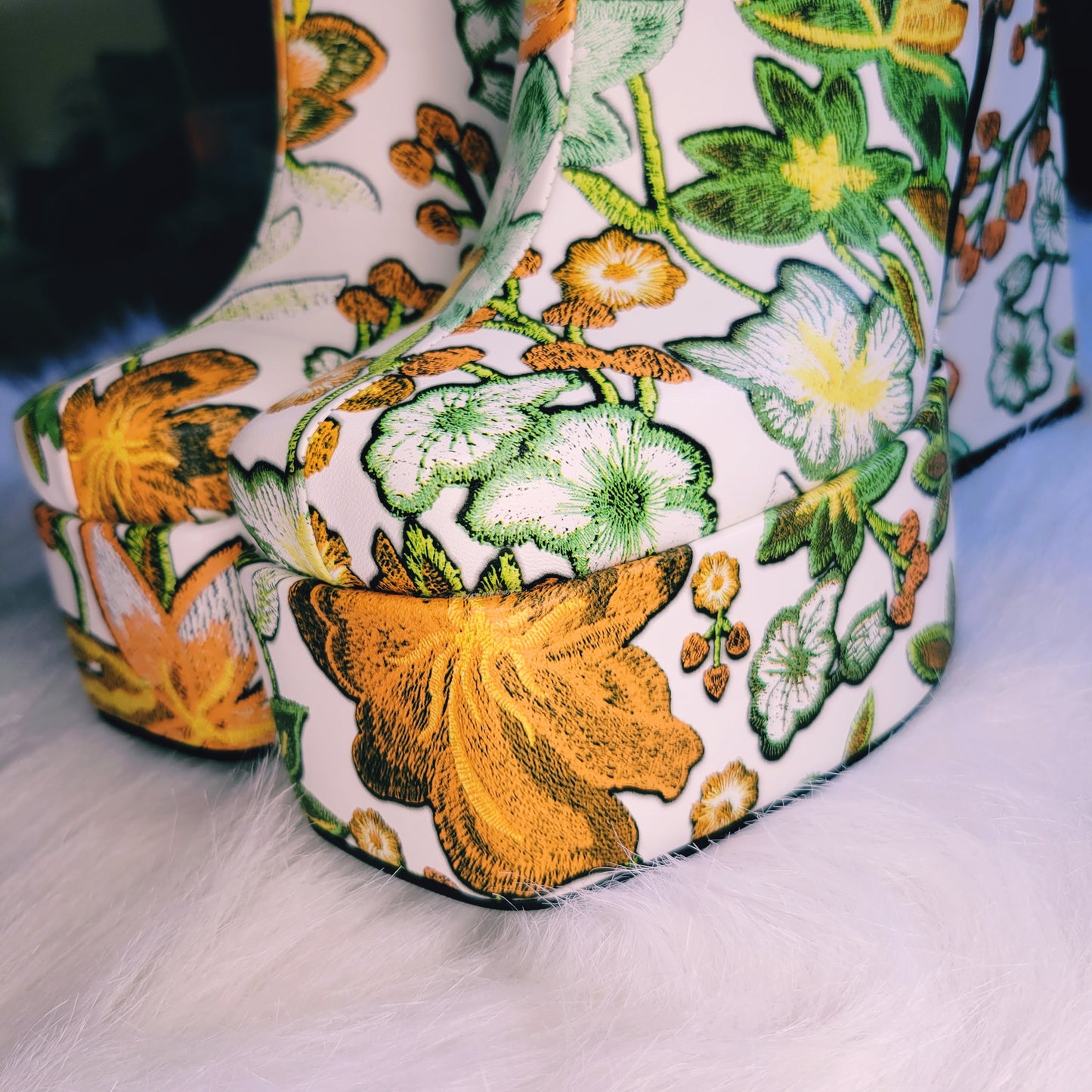 Retro 70's Platform ankle boots with orange and green floral print. Close up of squared toe and platform.